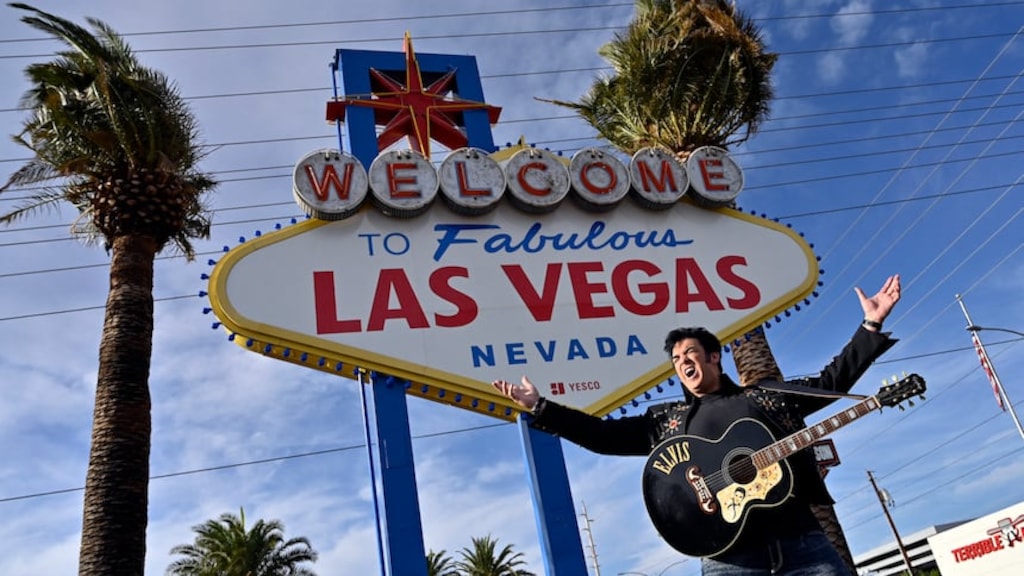 Un imitador de Elvis aparece en la foto junto a un letrero que dice: Bienvenido a la fabulosa Las Vegas. 