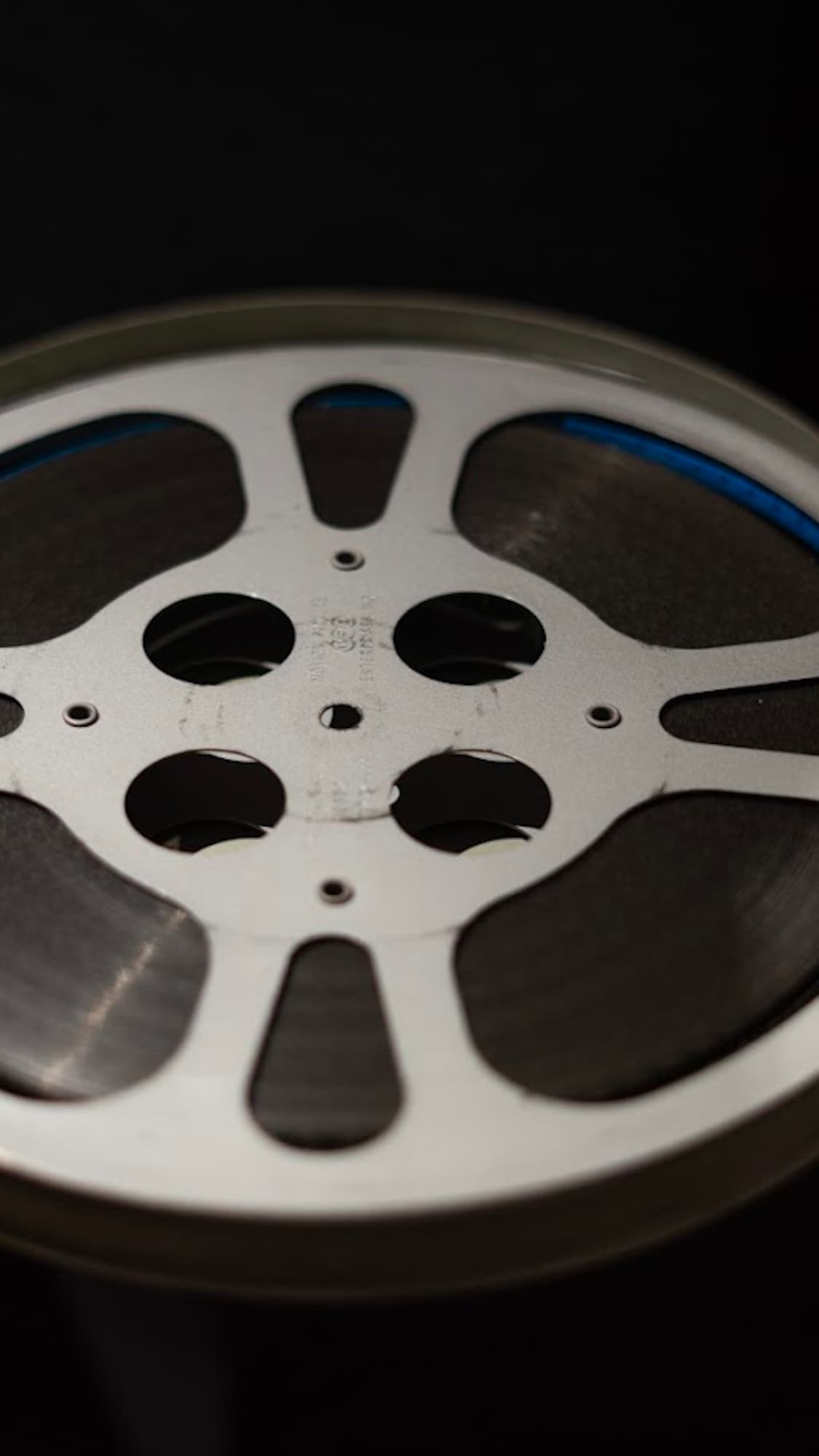 Les mains d'Elyas en train de tenir une bobine de film de 16 mm.