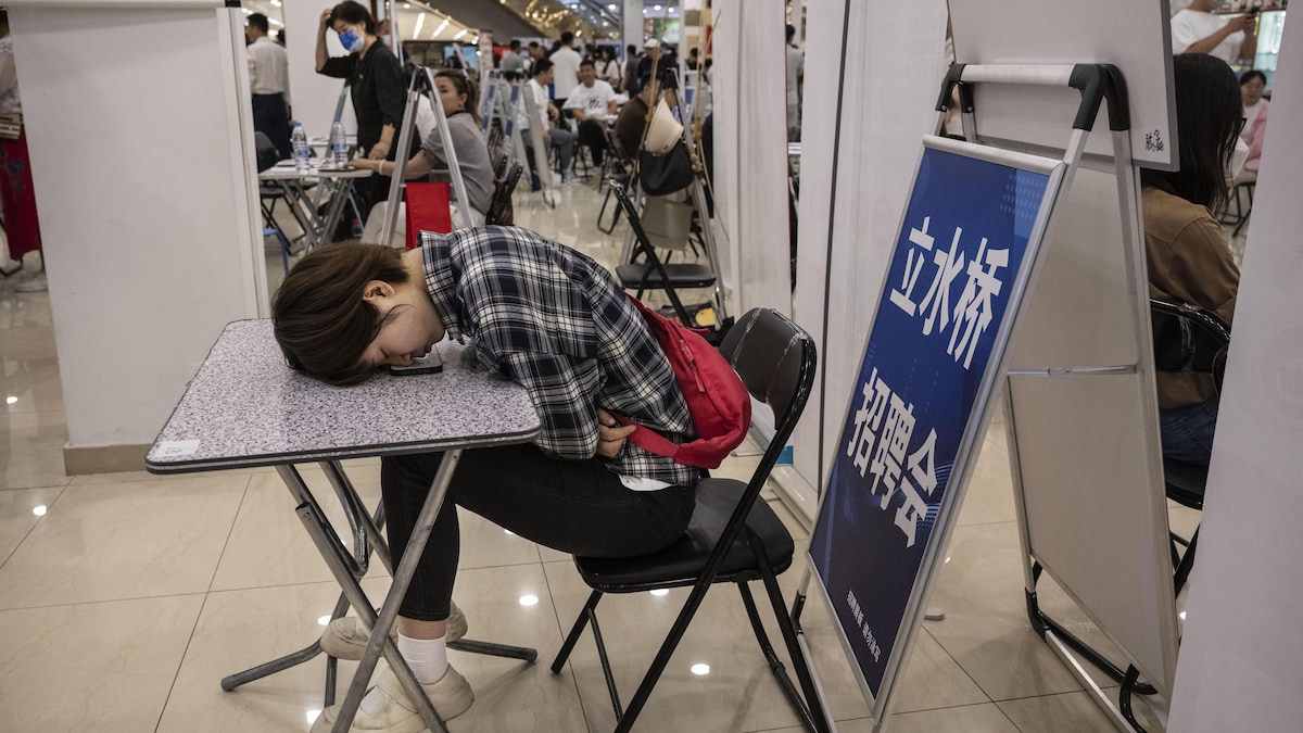 Une jeune femme découragée lors d'une foire de l'emploi en Chine.