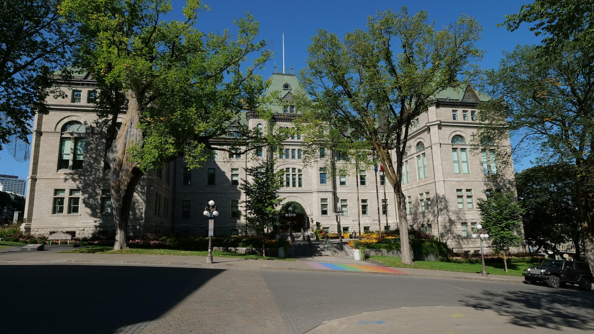La façade ensoleillée de l'hôtel de ville de Québec, avec ses ormes majestueux.