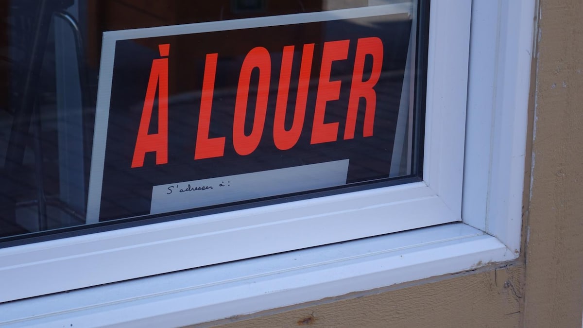 Une pancarte « À louer » dans une fenêtre.