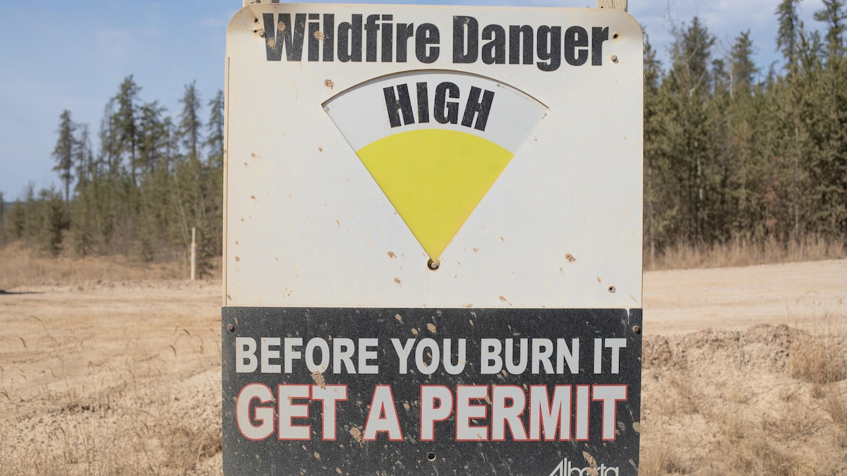 Un avis de danger élevé de feu de forêt est apposé à l'entrée d'un chemin d'accès à une exploitation de sables bitumineux au sud-est de Fort McMurray, en Alberta, le mercredi 24 avril 2024.