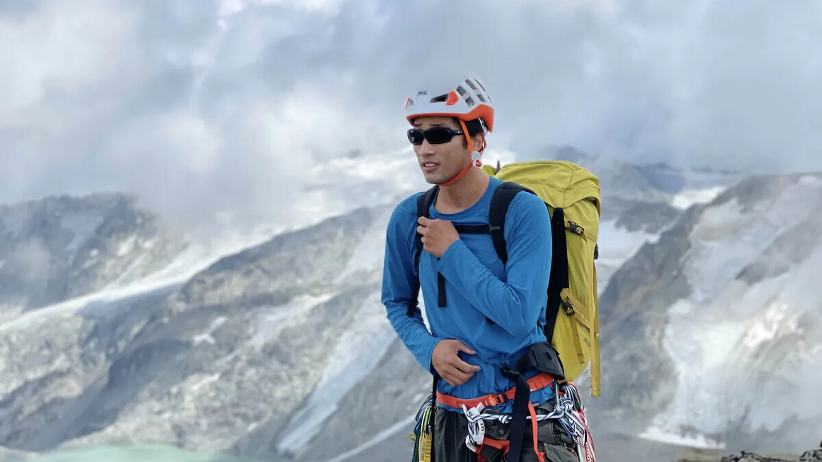 Steven Song en montagne, muni d'un équipement d'alpinisme.