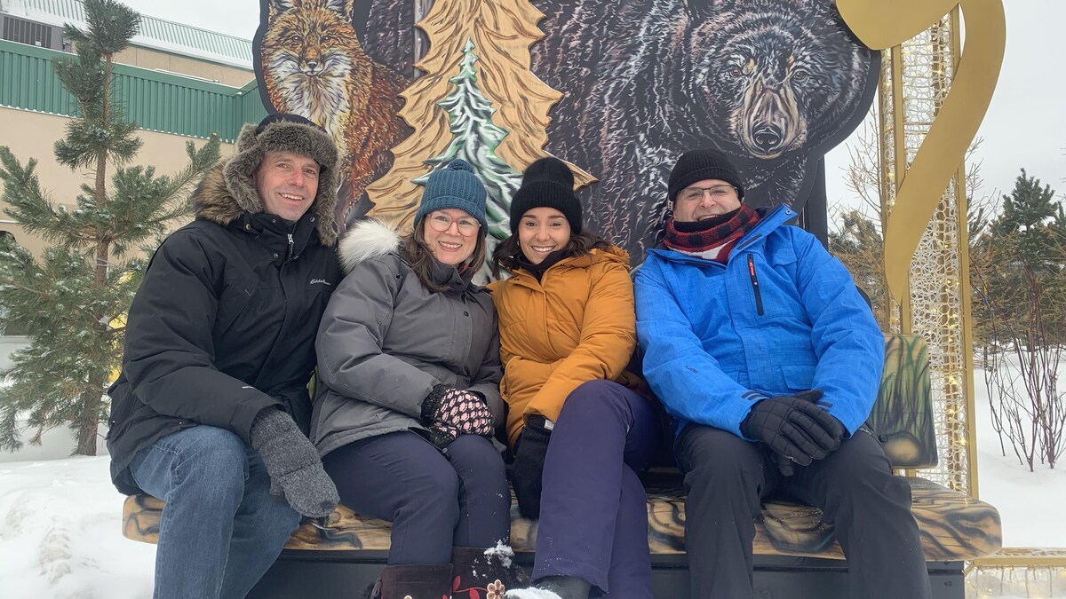 De gauche à droite : Richard Marion, Julie Plourde, Matisse Harvey et Marc-Éric Bouchard posent, souriants, au pied d'une image arborant un renard et un ours, en marge des Jeux d'hiver de l'Arctique de Wood Buffalo, en Alberta, le vendredi 3 février 2023.