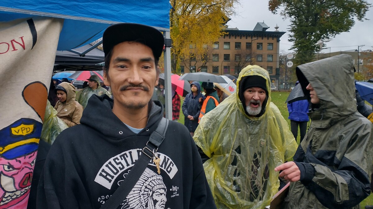 Un homme qui participe à un rassemblement pour le logement à Vancouver.