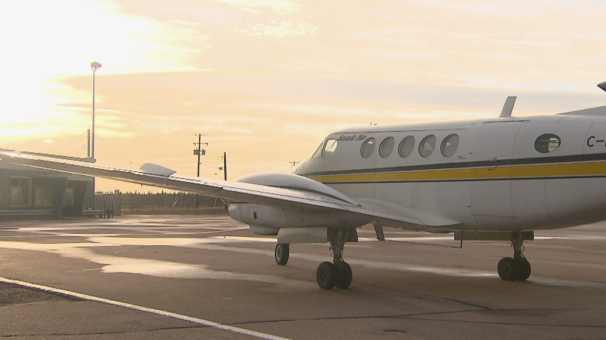 Un avion stationné sur le tarmac d'un aéroport.