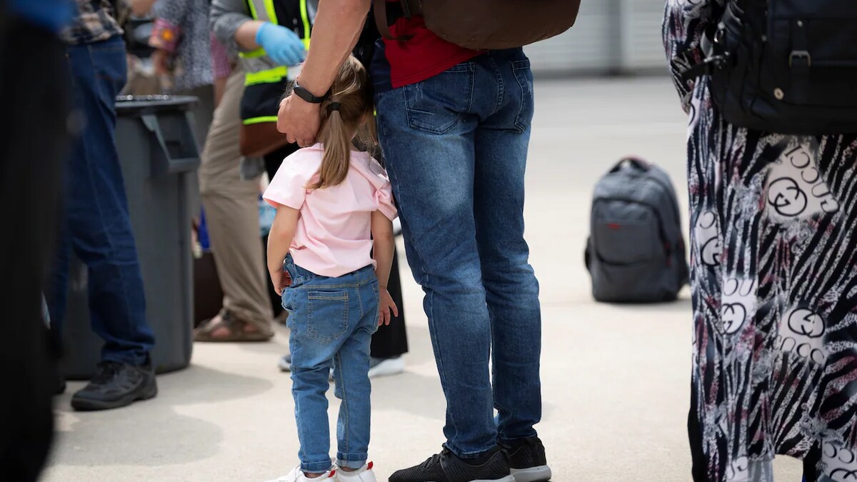 Enfant afghane et son père à l'aéroport. 