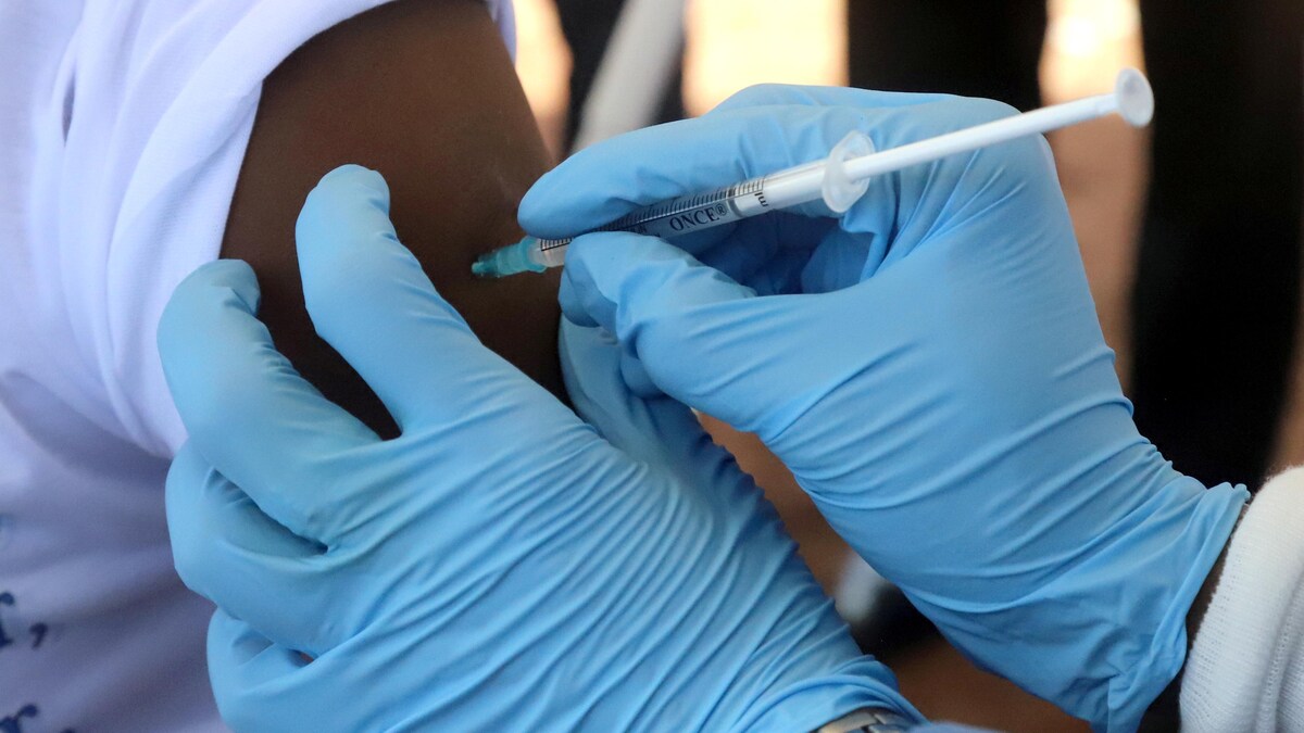 Un infirmier injecte un vaccin dans le bras d'une personne.