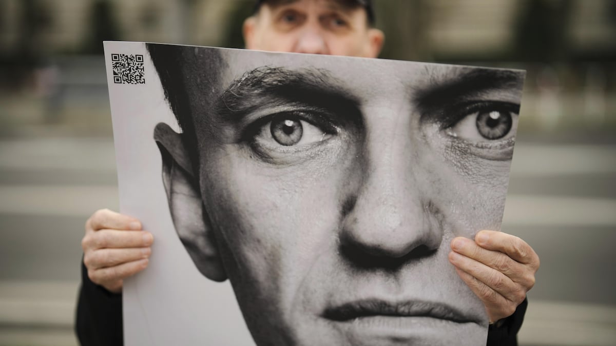 Un homme tient une affiche avec le portrait du leader de l'opposition Alexeï Navalny.