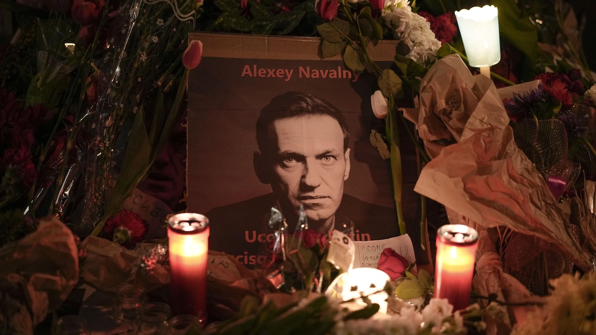 Des fleurs et des bougies entourent une photo d'Alexeï Navalny.