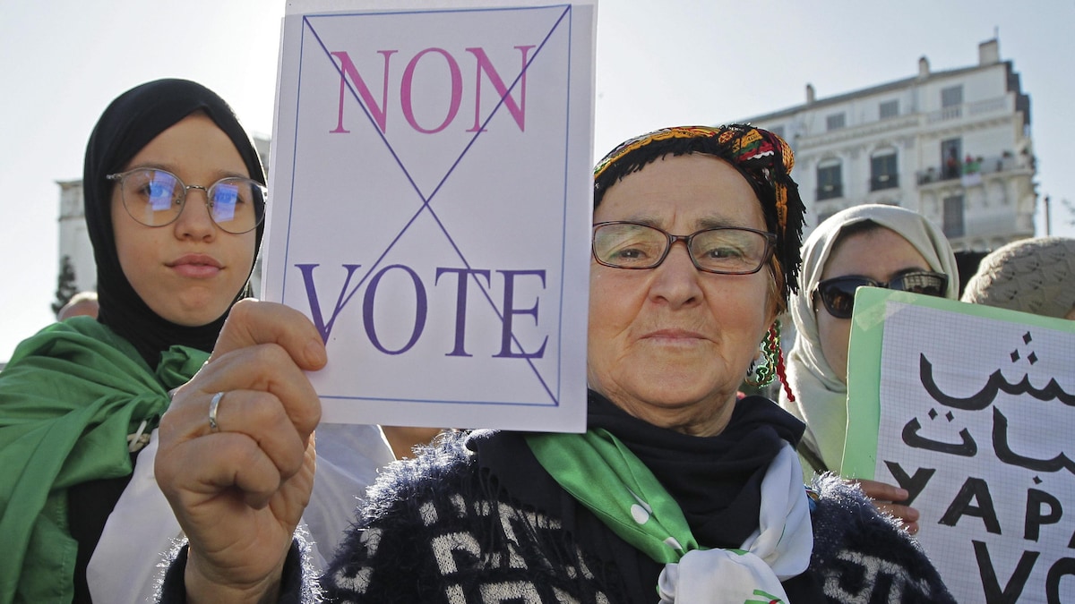 Une manifestante algérienne brandit une pancarte sur laquelle est écrit « Non vote »