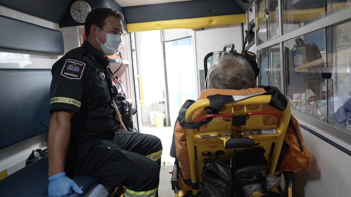 Un ambulancier qui s'occupe d'une personne âgée dans une ambulance.
