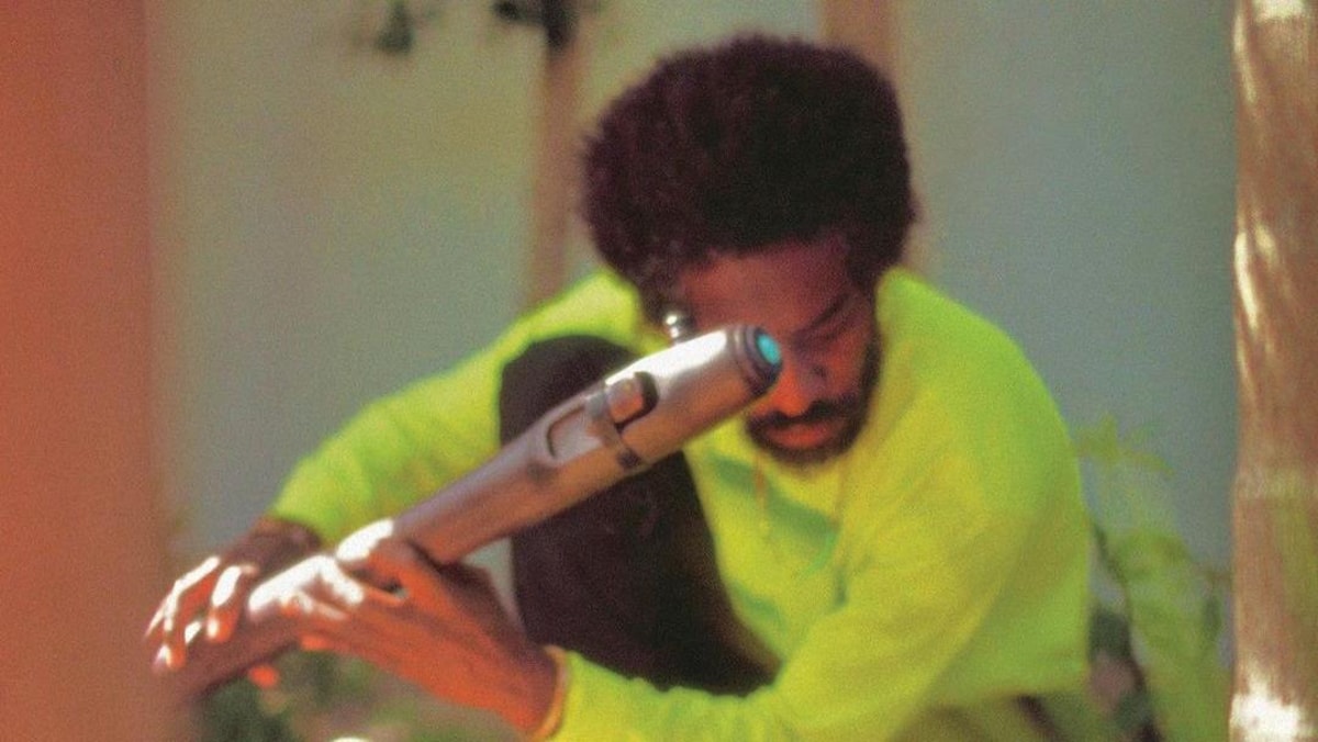 L'artiste tient une flûte qui ressemble à un sabre laser.