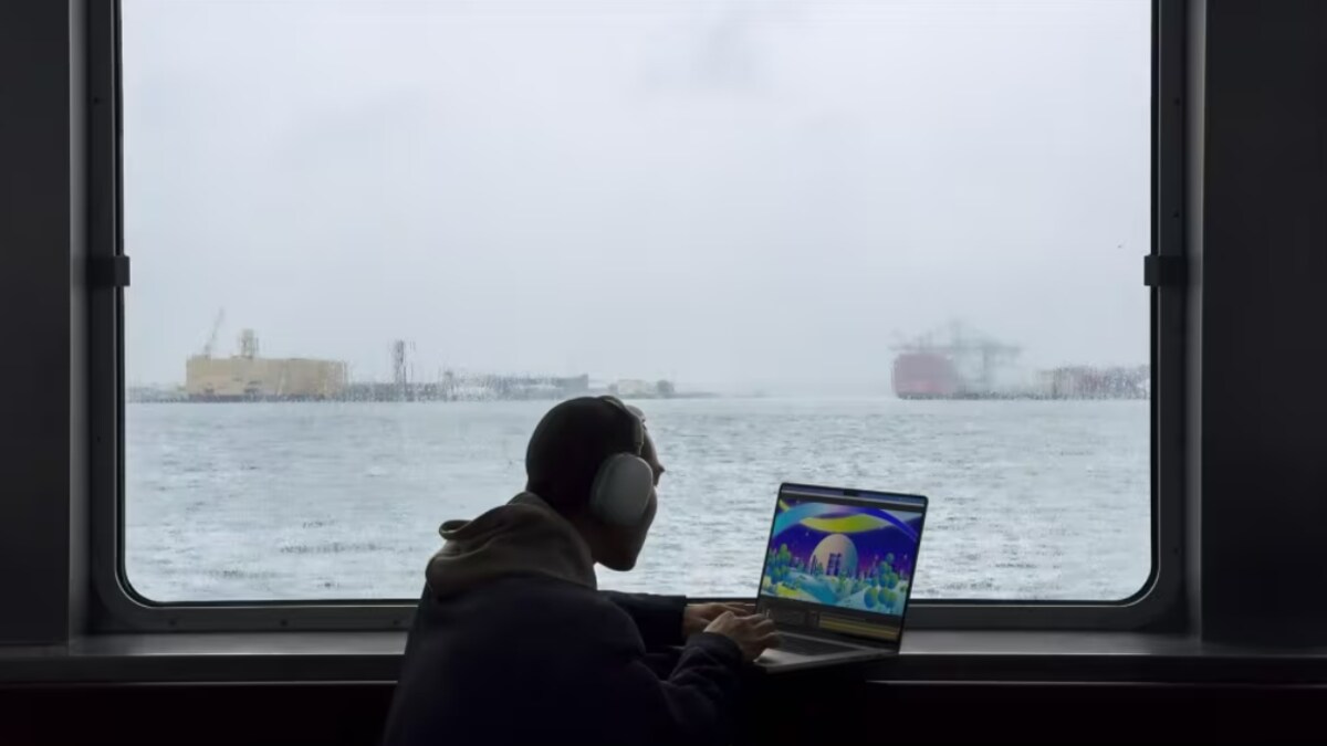 Un homme travaille sur un ordinateur à bord d'un bateau. 