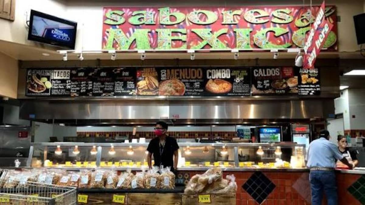 Des travailleurs et des clients dans un supermarché hispanique.