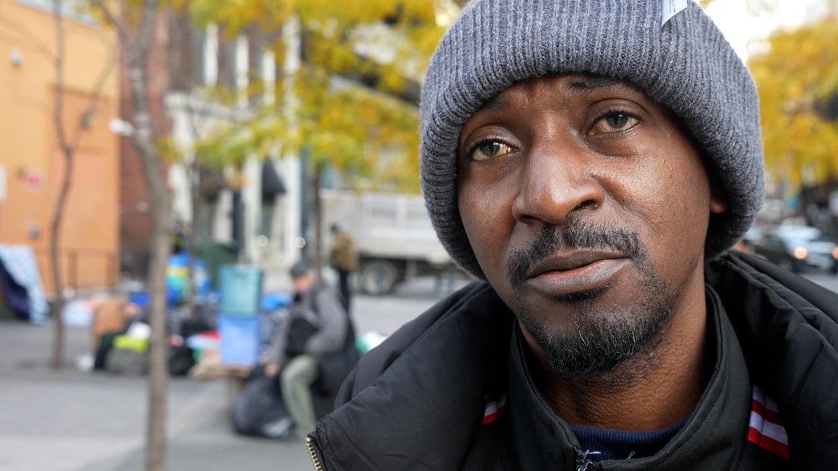 Le demandeur d'asile portant une tuque en entrevue devant le 129, rue Peter, un bureau pour sans-abri à Toronto.