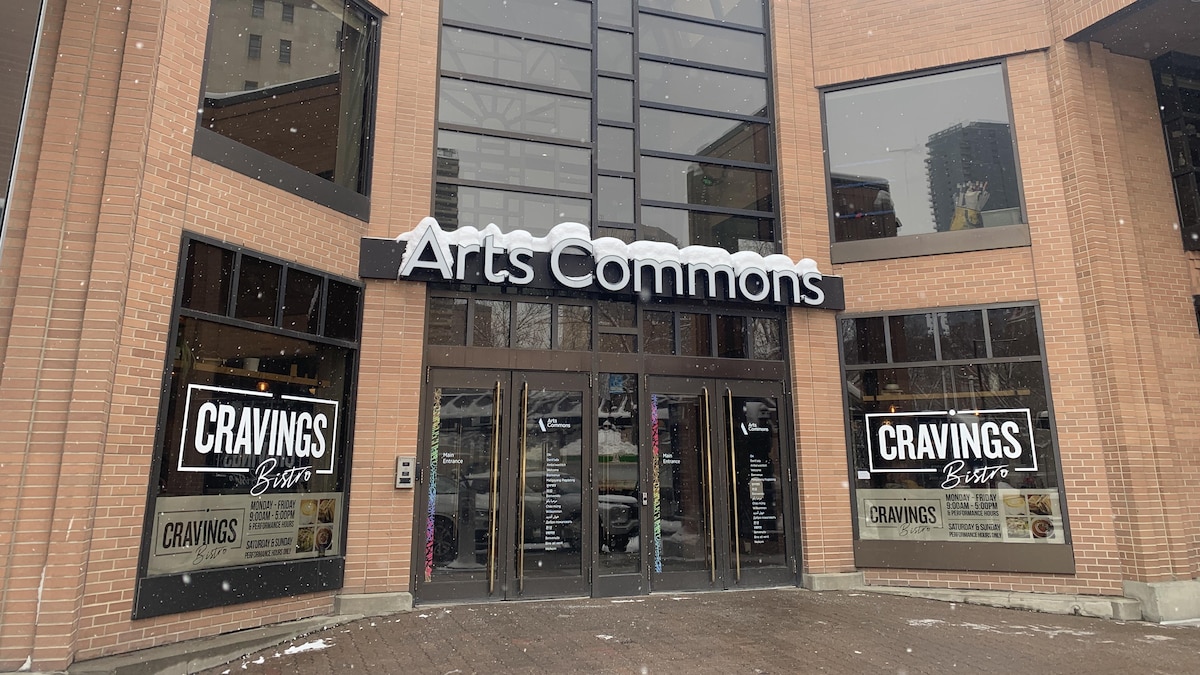 La facade du centre Arts Commons à Calgary avec de la neige qui tombe.