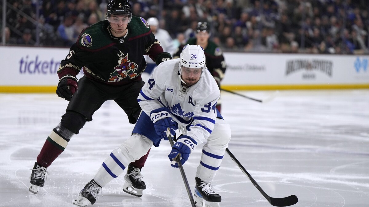 Auston Matthews des Maples Leafs de Toronto patine devant Michael Kesselring des Coyotes de l'Arizona au cours du match du 21 février 2024.