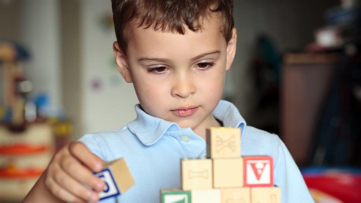 Un enfant autiste joue avec des blocs.