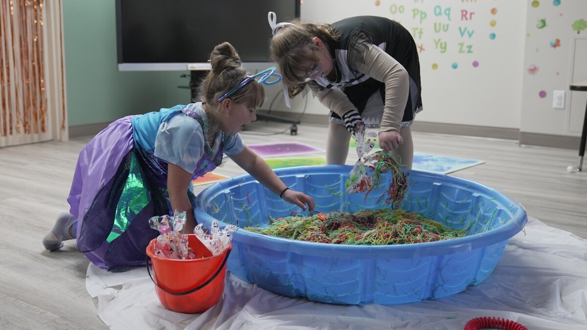 Deux filles fouillent dans une piscine remplie de spaghettis.
