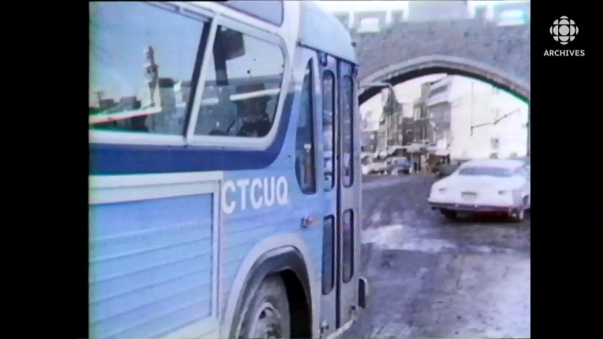 Autobus avec le sigle de la CTCUQ roulant sur une rue de la vieille ville fortifiée de Québec.