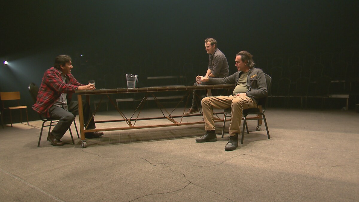 Trois hommes discutent autour d'une table