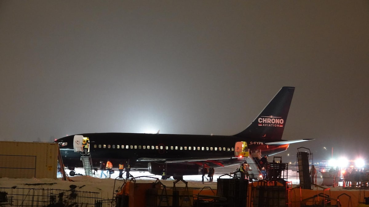 Un avion de la compagnie Chrono sur le tarmac d'un aéroport la nuit.