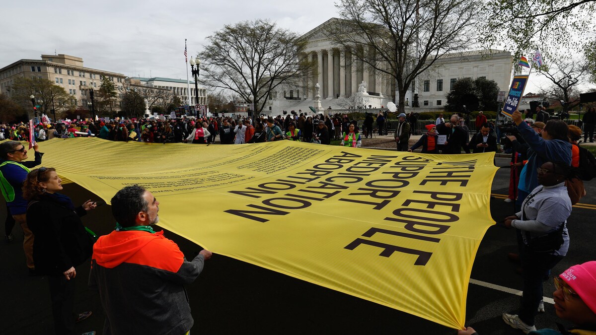 Des manifestants pro-avortement tiennent une banderole devant la Cour suprême des États-Unis.