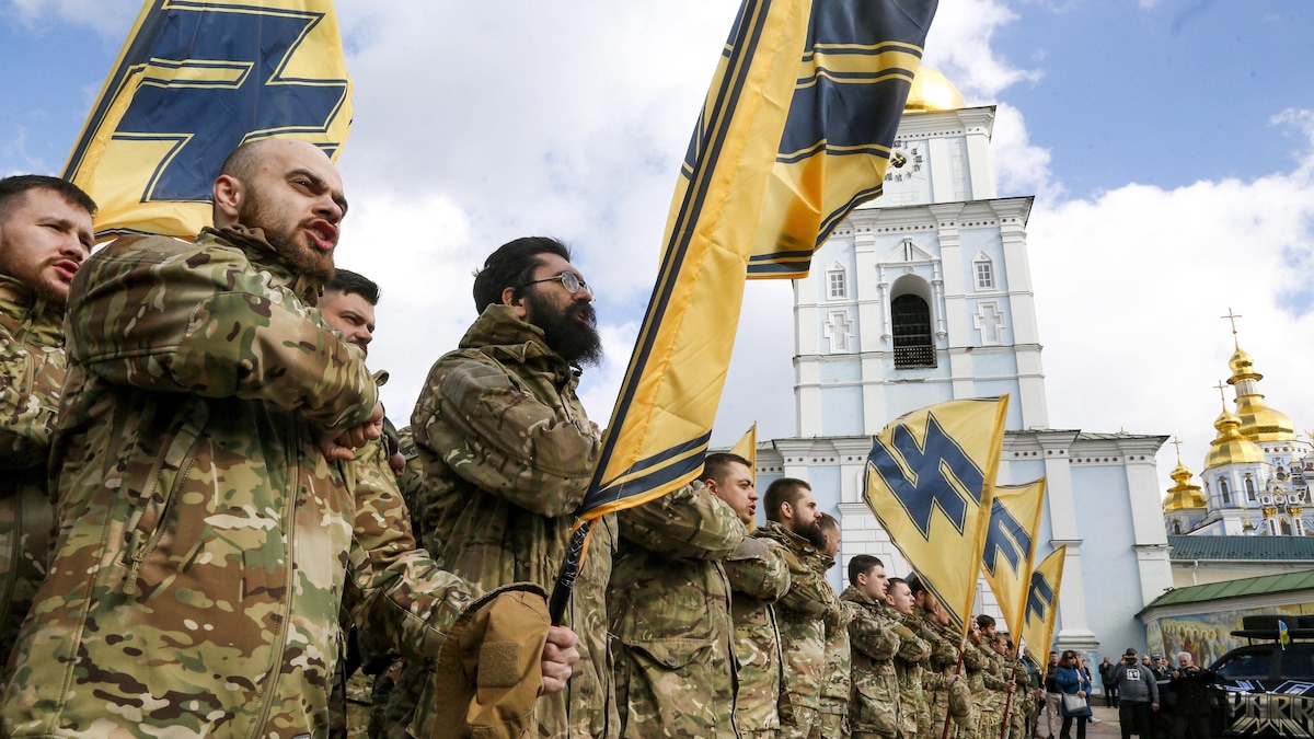 Des volontaires ukrainiens du bataillon Azov avec leurs drapeaux démontrent leur force, lors de la Journée des volontaires ukrainiens à Kiev, en Ukraine, le samedi 14 mars 2020.