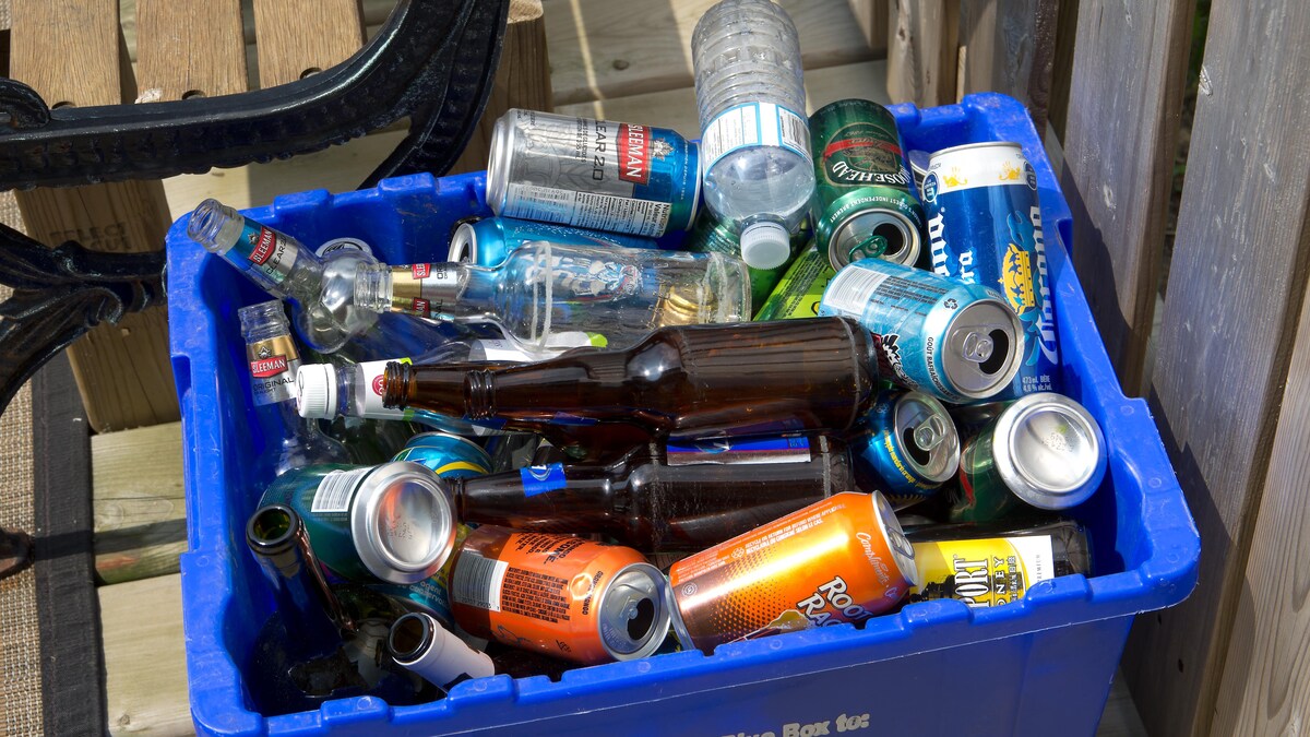 Un bac de recyclage rempli de bouteilles et de canettes.