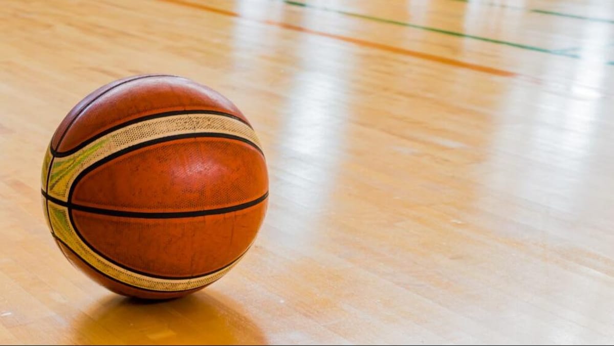 Un ballon de basketball sur le sol d'un gymnase. 
