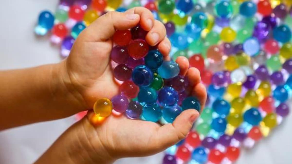 Une poignée de perles gonflant dans l'eau dans des mains.