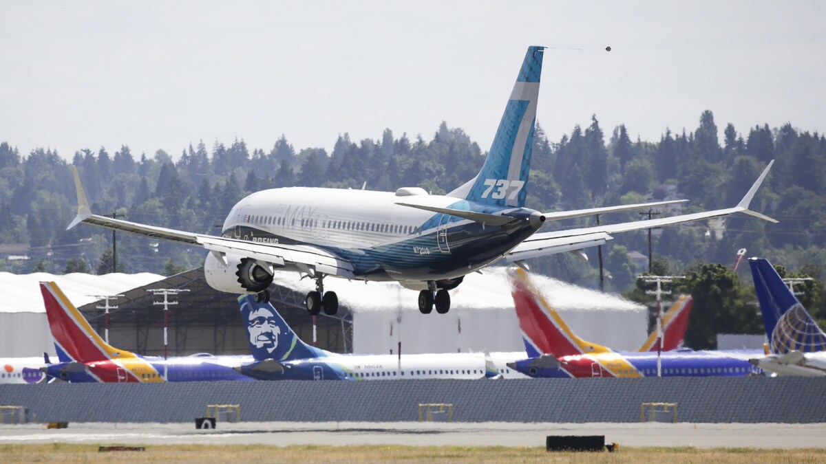 Un Boeing 737 MAX survole une piste d'atterrissage.