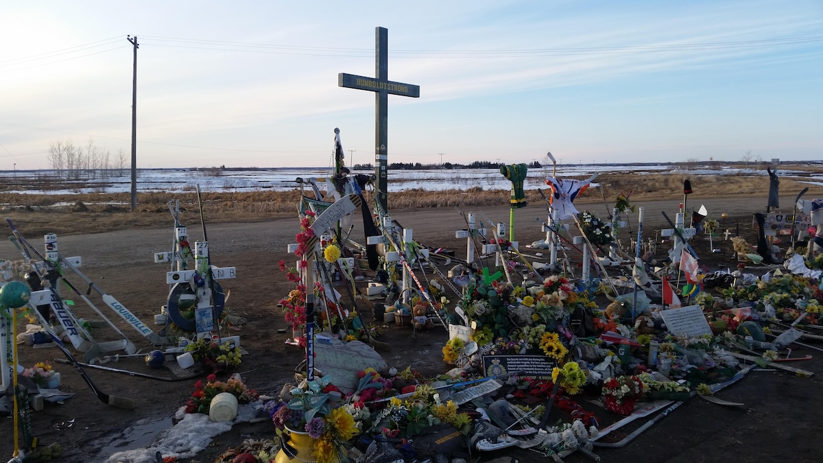 Des fleurs, des lettres et des objets bordent des croix où sont inscrits les noms des victimes. Au centre, sur une grande croix, on peut lire « Humboldt Strong ». 