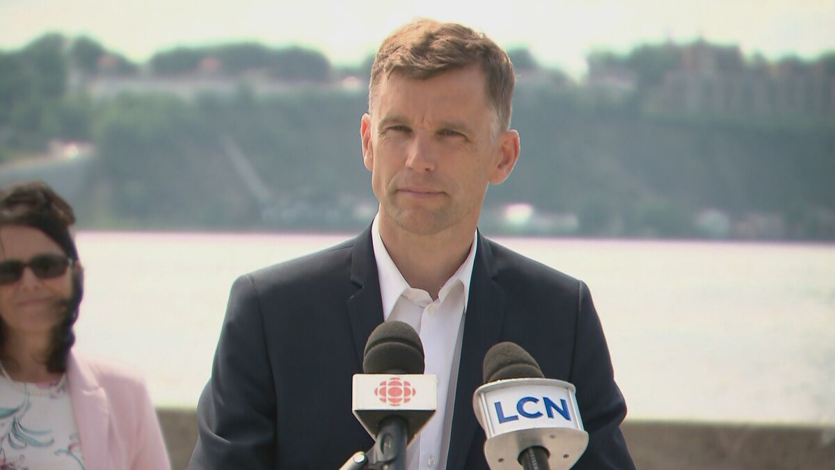 Bruno Marchand répond aux questions des journalistes lors d'un point de presse à l'extérieur, en bordure du fleuve Saint-Laurent, à Québec.
