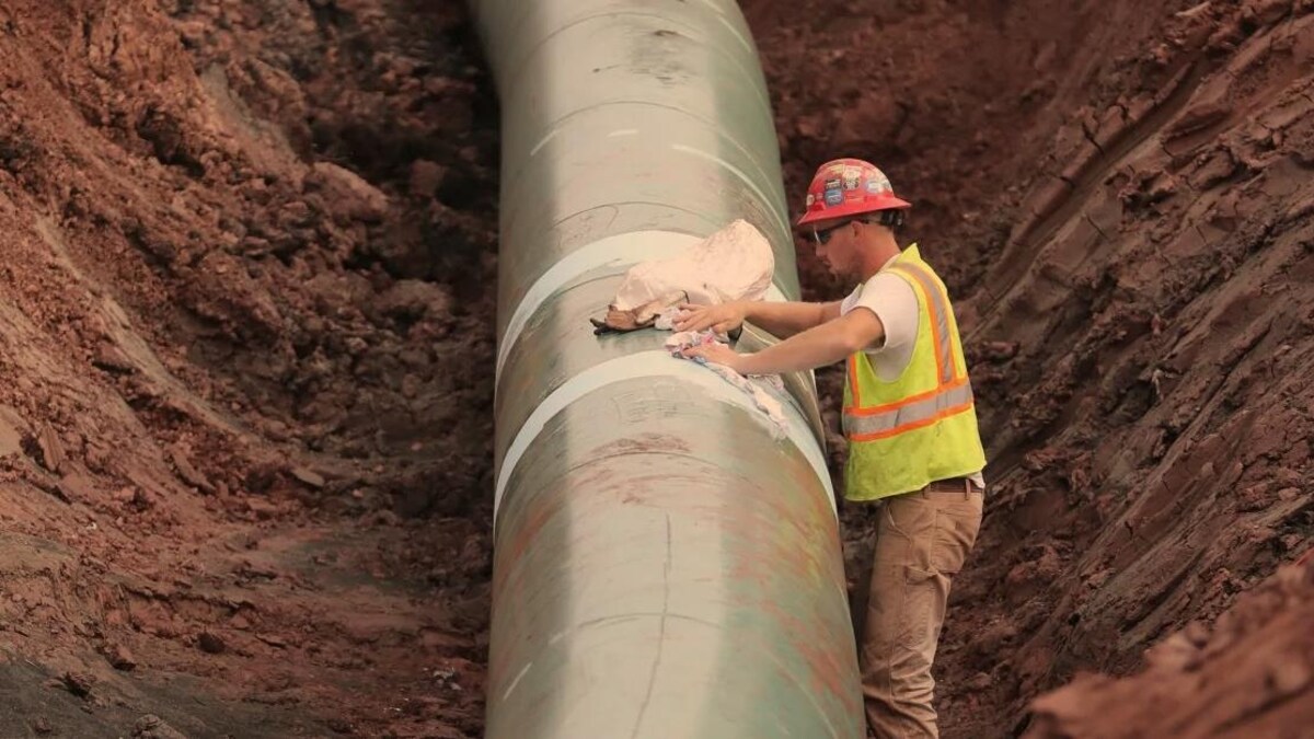 Un travailleur installe un pipeline.