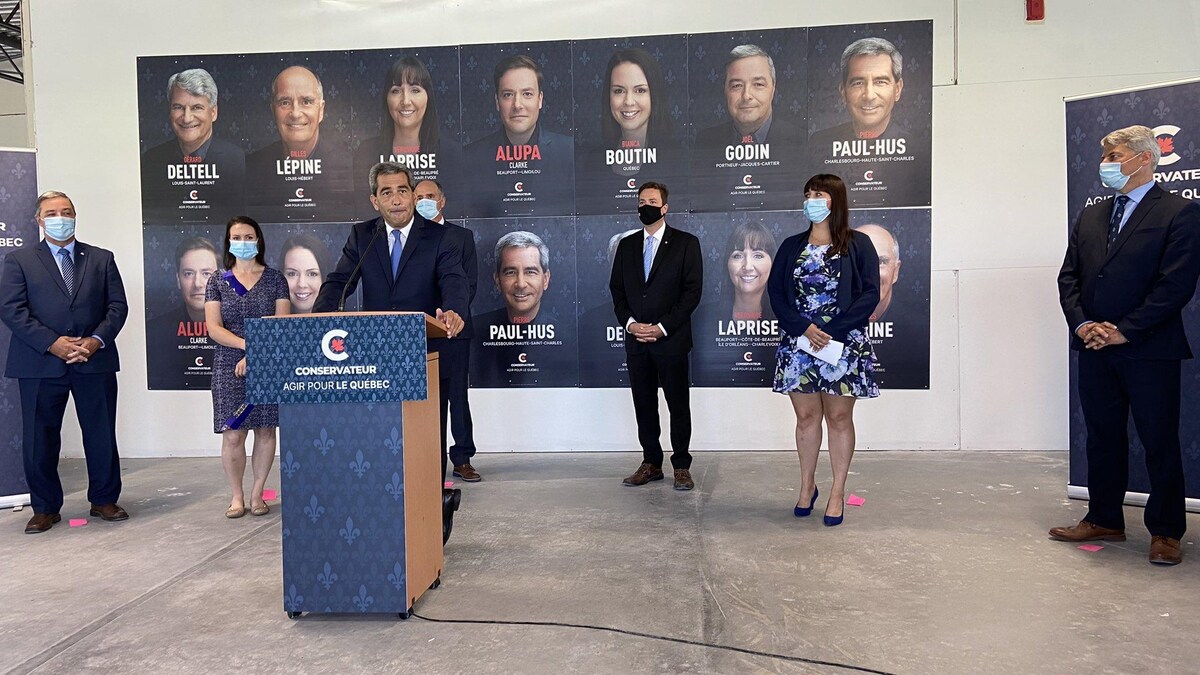 Les sept candidats conservateurs dans la région de Québec donnent un point de presse. Le député sortant Pierre Paul-Hus prend la parole. Il se tient debout, derrière un lutrin.