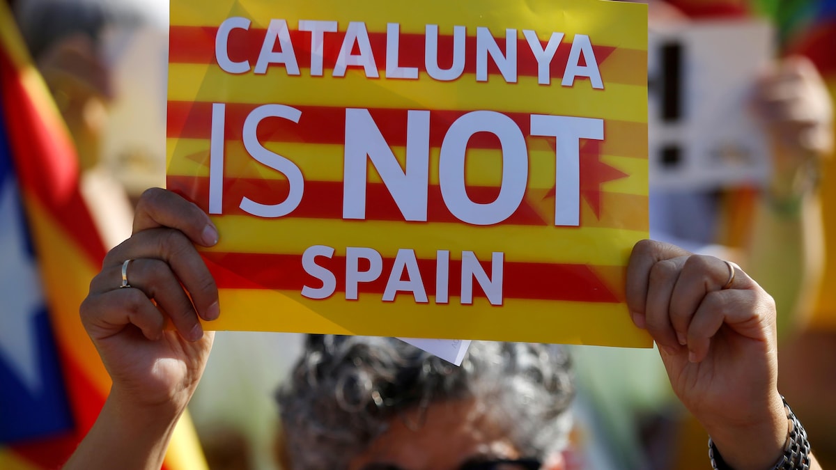 Une femme tient une affiche indiquant que la Catalogne n'est pas l'Espagne.