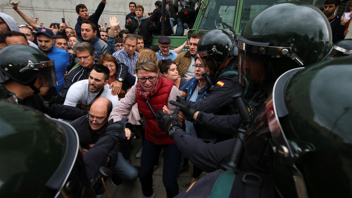 Des agents de la Garde civile espagnole tentent de déloger des Catalans désirant participer au référendum sur l'indépendance.