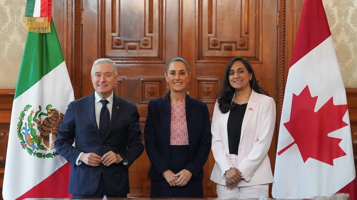 François-Philippe Champagne, Claudia Sheinbaum et Anita Anand entre un drapeau mexicain et un drapeau canadien.