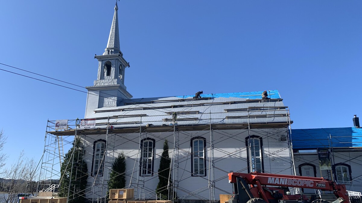 Des échafaudages sont installés à l'extérieur de la chapelle et des ouvrier travaillent sur la toiture. 