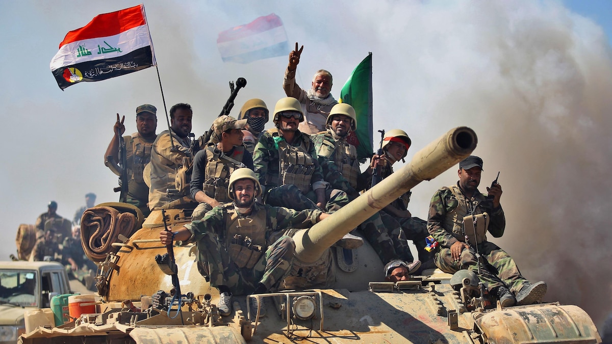 Des combattants irakiens saluent la victoire remportée à Hawija.