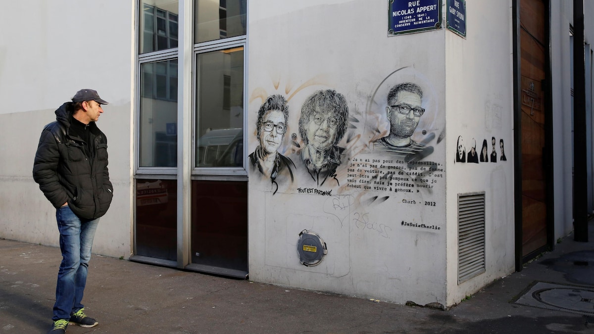Un passant devant les anciens bureaux de Charlie Hebdo, cible d'une attaque terroriste il y a deux ans.