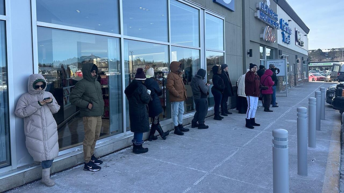 Des gens font la file à l'extérieur d'une clinique sans rendez-vous, en plein hiver. 