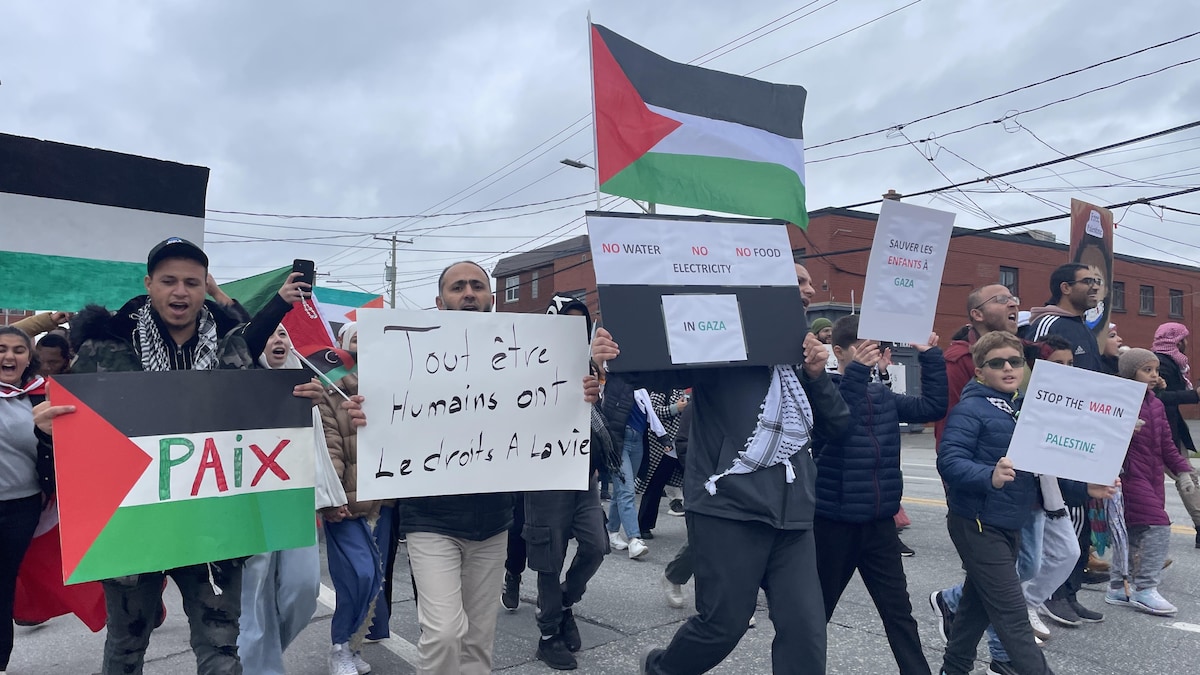 Des gens tiennent des pancartes qui encouragent la paix à Gaza.