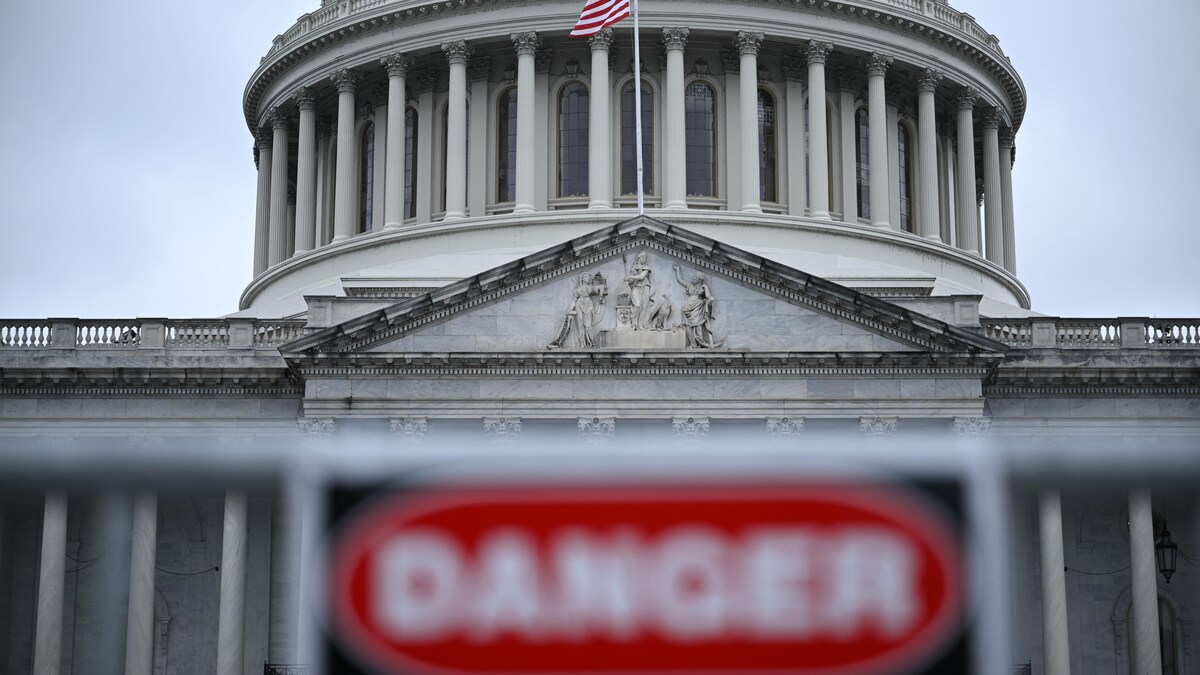 Le Capitole à Washington avec à l'avant-plan, un peu flou, un avertissement de «Danger».