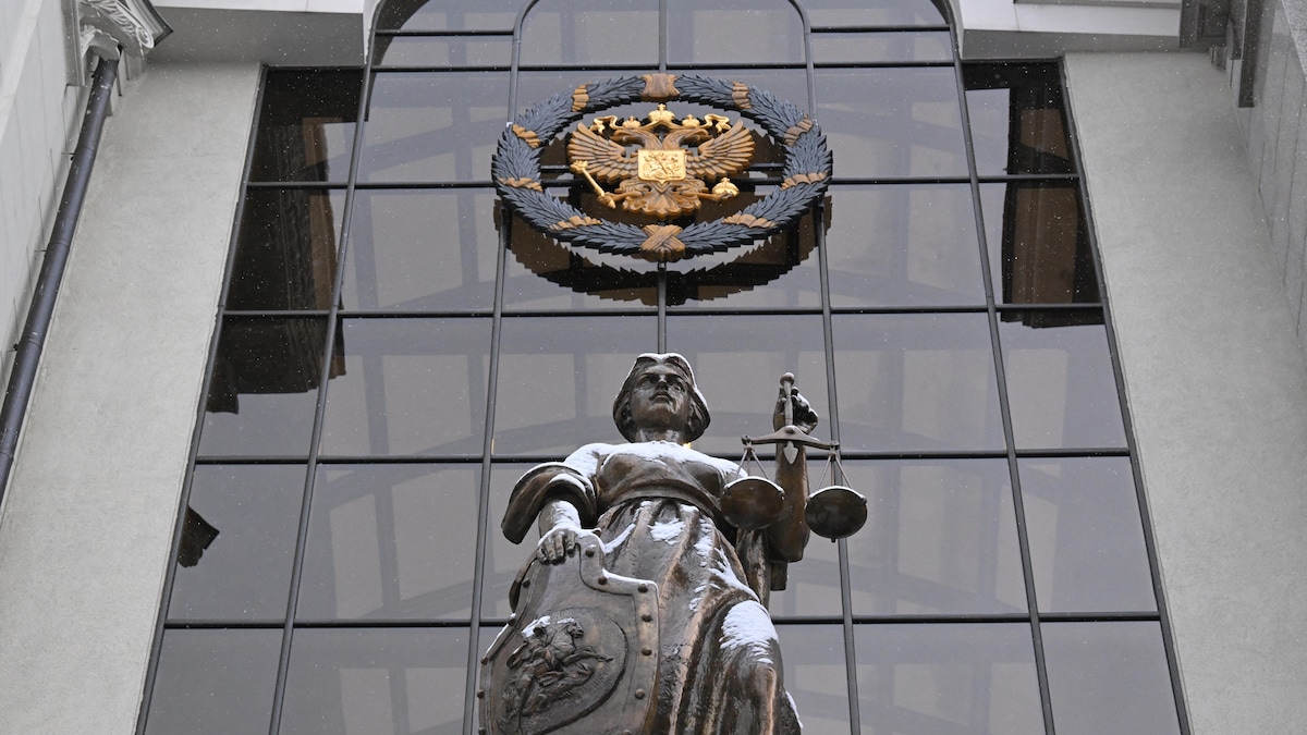 Une statue de Thémis, déesse grecque de la justice, et l'emblème de l'État russe à l'entrée de la Cour suprême de la Russie, à Moscou.