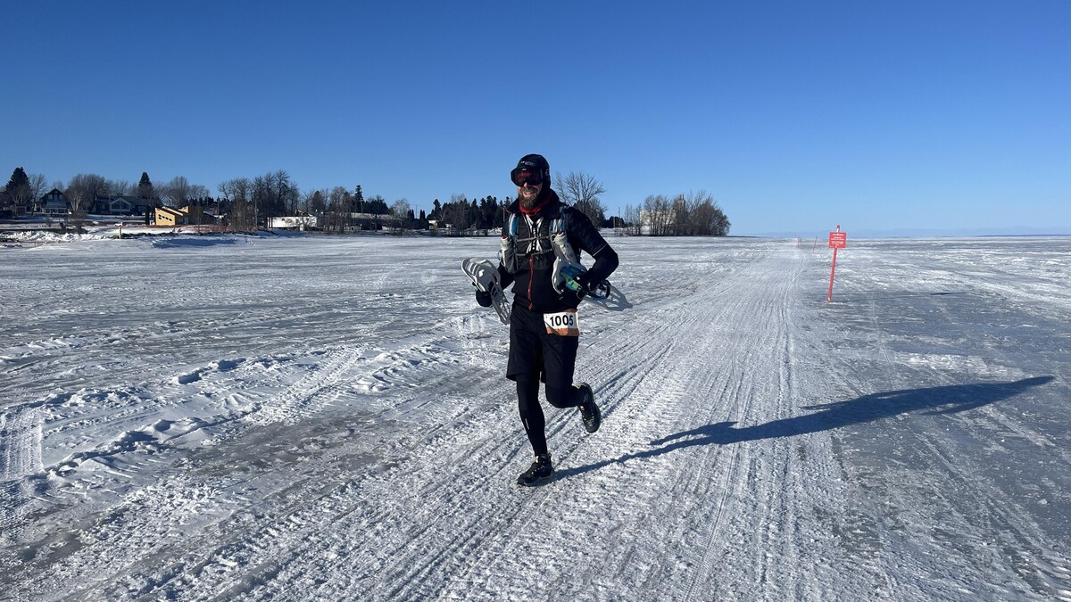 Un homme court sur un lac gelé.