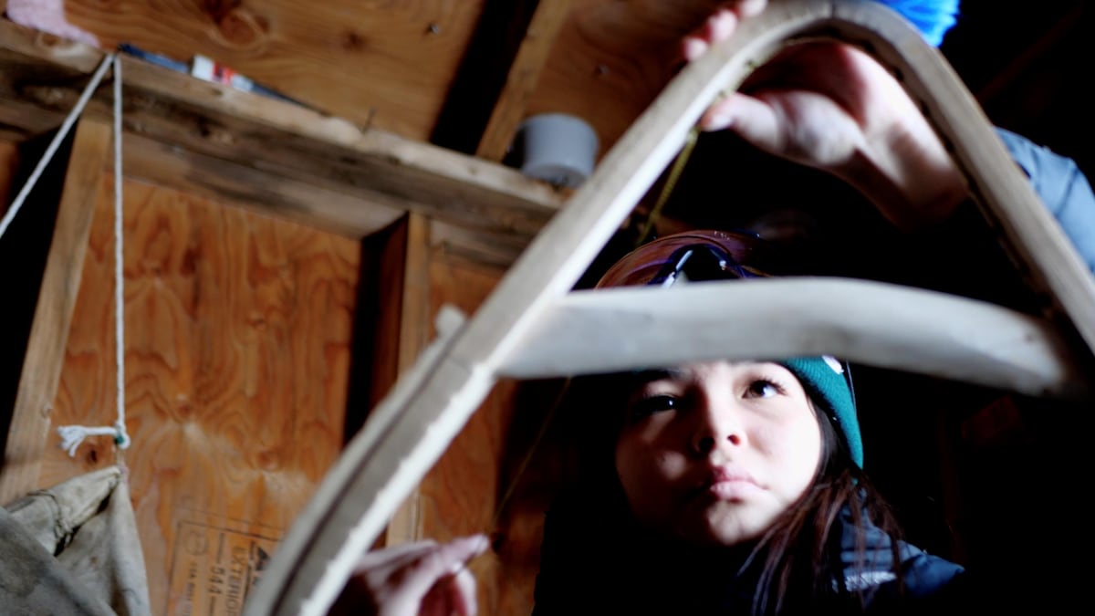 Un jeune femme fabrique des raquettes. 