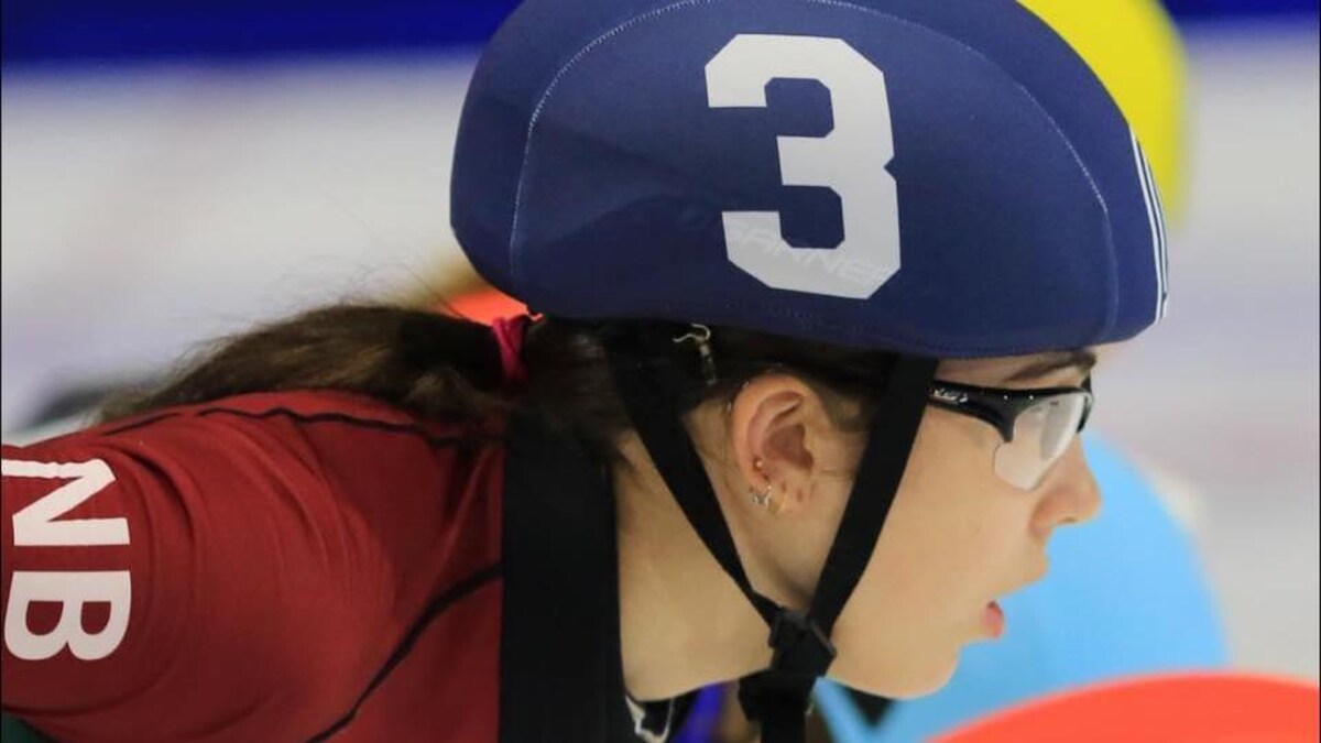 Jeune femme avec lunettes et casque de patinage qui regarde vers la droite.